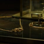 Lightweight gold necklace and bangle in a dark luxury jewellery boutique